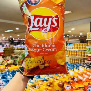 Lay’s Cheddar & Sour Cream flavoured chips pack with crispy potato chips